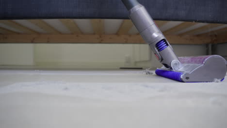 Super-Dusty-space-under-bed-with-scattered-dust-balls-and-vacuum-cleaner
