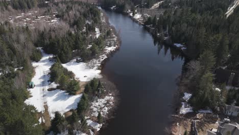 Drohnenflug-über-Einem-Fluss-Mit-Schneebedeckten-Kiefernwäldern-In-Saint-Côme,-Einer-Gemeinde-In-Der-Region-Lanaudière-In-Quebec,-Kanada