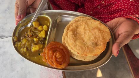 Close-up-shot-of-puri-bhaji-served-with-potato-curry-along-jalebi-at-a-bihari-shop-at-daytime