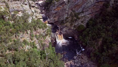 Profile-view-of-water-falling-inside-Leven-Canyon-during-daytime-in-Tasmania,-Australia