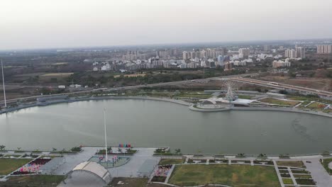 La-Cámara-Del-Dron-Se-Mueve-De-Izquierda-A-Derecha-Mostrando-Una-Zona-Residencial-Y-Pequeños-Arbustos-Alrededor-Del-Lago