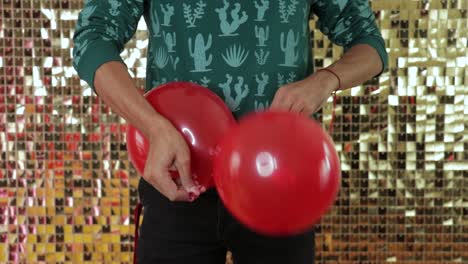 Tying-red-balloons-together,-making-party-decorations