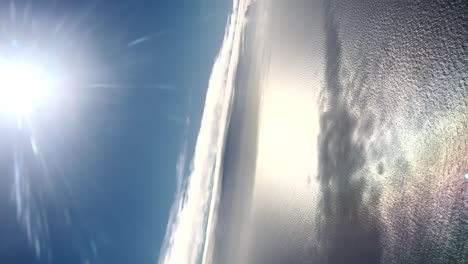 Luftaufnahme-Von-Blauem-Himmel-Und-Meer,-Vertikal,-Klares-Wetter,-Strahlende-Sonne,-Wasserwellen