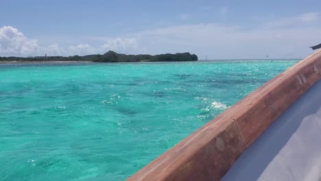 POV-watching-birds-fly-while-sail-motorboat-on-azure-sea-water-near-mangrove,-Los-Roques-Caribbean-sea