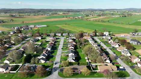 Aerial-wide-shot-of-farm-fields-and-Suburb-Neighborhood-in-American-State-during-sunny-day