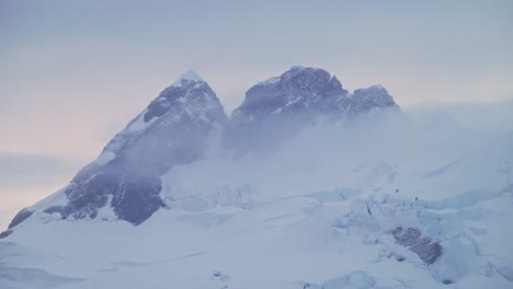 Montañas-Invernales-Al-Atardecer-En-La-Antártida,-Paisaje-De-Cumbre-Montañosa-Con-Espectaculares-Nubes-Al-Atardecer-Y-Cielo-En-La-Península-Antártica,-Nieve-Y-Hielo-Con-Un-Ambiente-Brumoso-Atmosférico