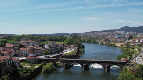 Barcelos-cityscape-with-medieval-bridge-over-the-tranquil-Cavado-River,-Portugal---aerial