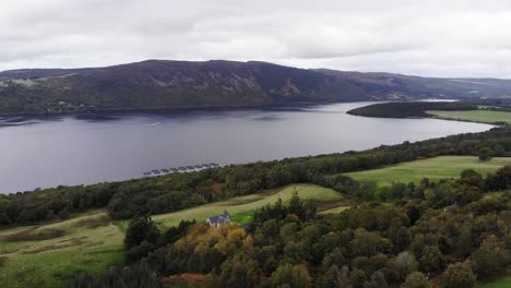 Aerial-View-Over-Green-Valley-River-Bank-Trees-With-Loch-Ness-In-The-Scottish-Highlands