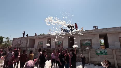 Una-Máquina-Rocía-A-Un-Hombre-Con-Agua-Jabonosa-Sobre-Los-Hombres-Que-Juegan-Debajo