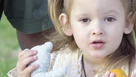 Close-up-of-adorable-little-girl-playing-with-her-toys-in-the-park