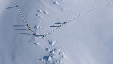 Aerial-top-down-showing-Mountain-Climber-Group-ski-mountaineering-snowy-mountain-in-Italy