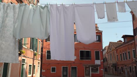 Trocknende-Wäsche-Hängt-An-Einem-Seil,-Das-Zwischen-Den-Gebäuden-Auf-Der-Wunderschönen-Plaza-In-Venedig-Angebracht-Ist