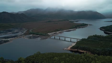 Tasmanian-landscape-with-Lake-Burbury-and-a-bridge-under-a-foggy-day-in-Australia