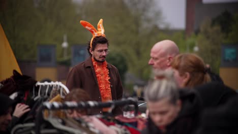 Man-with-brown-hair-and-glasses-and-funny-orange-rabbit-ears-decoration-close-up