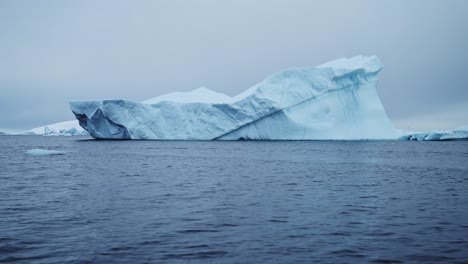 Hermosos-Icebergs-Azules-De-La-Antártida,-Iceberg-Flotando-En-El-Agua-Del-Mar-Del-Océano-De-La-Península-Antártica-En-Un-Clima-Frío-De-Invierno,-Vista-De-ángulo-Bajo-Y-Gran-Angular-Del-Paisaje-Marino-Y-Paisajístico