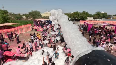 Hombres-Jugando-Holi-Debajo-Siendo-Bañados-Con-Agua-Jabonosa-Por-Un-Hombre-Desde-Arriba