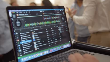 Slow-motion-shot-of-a-DJ's-deck-on-his-laptop-at-a-wedding-event