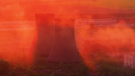 Industrial-smokestacks-surrounded-by-smoke-emissions-illuminated-by-the-orange-sunlight,-high-contrast-close-up-shot