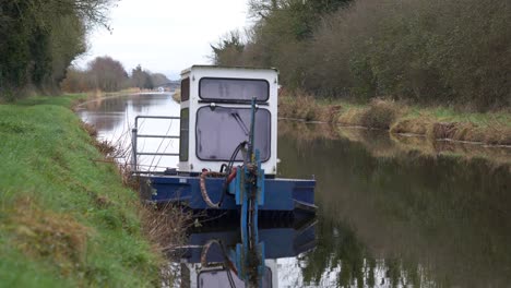 Barco-De-Mantenimiento-Del-Canal-En-Aguas-Tranquilas,-Gran-Canal,-Kildare,-Irlanda,-Día-Nublado,-Escena-Serena