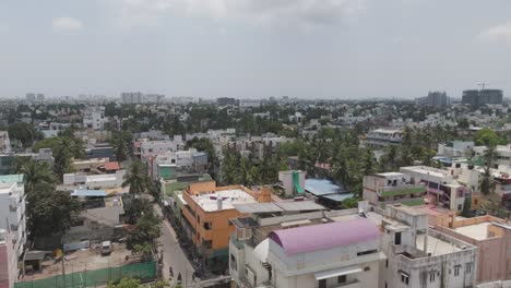 A-mesmerizing-aerial-perspective-of-Chennai,-highlighting-the-city's-bustling-streets-and-towering-skyscrapers-amidst-a-cloudy-ambiance