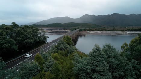 Aerial-shot-of-Lake-Burbury-with-mountains-at-background-on-a-cloudy-day-in-Tasmania,-Australia