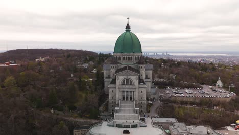 Luftaufnahme-Von-Vorne-Des-St.-Josephs-Oratoriums-Von-Mount-Royal,-Römisch-katholische-Basilika-Minor-In-Montreal,-Quebec,-Skyline-Der-Stadt-In-Der-Ferne