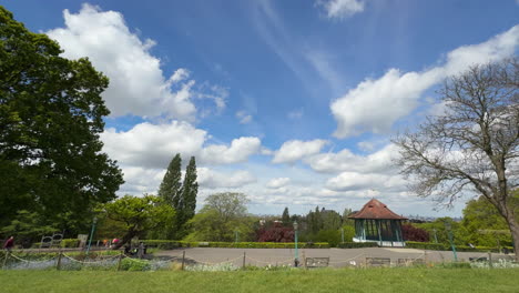 Jardines-Horniman,-Forest-Hill,-Londres,-Lapso-De-Tiempo,-Cielo-Azul,-Nubes-Blancas-Que-Se-Mueven-Rápidamente,-Soporte-Para-Banda,-Movimiento-Lento-De-Izquierda-A-Derecha