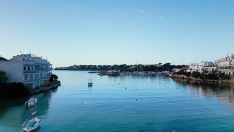Tranquil-harbor-scene-in-Portopetro,-Mallorca,-with-boats-and-clear-blue-sky