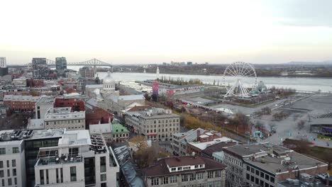 Aerial-view-of-The-Old-historical-Port-of-Montreal-capital-city-of-Quebec,-Canada,-drone-fly-above-Saint-Lawrence-River-at-sunset