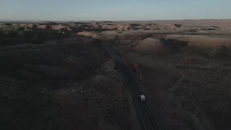 In-the-barren-expanses-of-Utah,-USA,-a-camper-truck-journeys-through-the-desolate-landscape,-embodying-the-spirit-of-van-life,-independence,-adventure,-the-freedom-to-roam-nature's-untouched-beauty