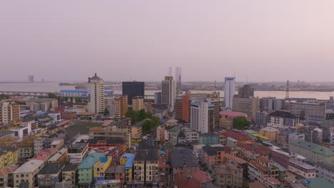 "Experience-Lagos-like-never-before-with-breathtaking-aerial-views-of-its-iconic-high-rise-buildings-towering-over-the-bustling-cityscape,-captured-beautifully-at-sunset