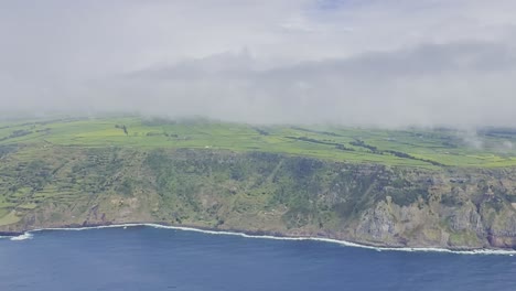 Lush-green-landscape-of-Sao-Miguel,-Azores-with-cliffside-ocean-views,-partly-cloudy-skies