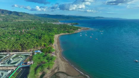 Aerial-drone-flight-over-coastline-of-Sarangani-with-beach-and-traditional-bangka,-fishing-boats-in-south-Philippines
