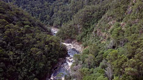 Forward-aerial-view-of-water-stream-flowing-in-Leven-Canyon-in-Tasmania,-Australia-during-daytime