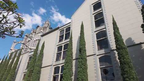 Palace-of-Culture-Rafael-Uribe-Uribe-in-Medellín,-flanked-by-towering-cypress-trees-under-a-clear-sky