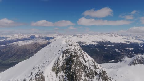 Drone-revealing-shot-of-Mountaineering-Team-reaching-summit-of-snowy-mountain-in-Italy