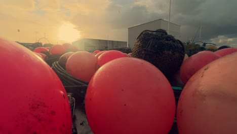 Bright-red-buoys-embellish-the-docks-of-a-scenic-Spanish-fishing-village,-firmly-attached-to-the-coastal-pier,-providing-a-glimpse-into-the-charm-of-this-cozy-harbor-and-its-fishing-community