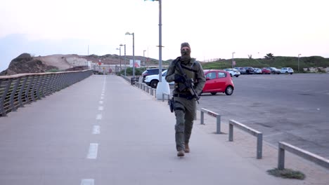 Hombre-Vestido-De-Militar,-Encapuchado-Y-Corriendo-Con-Una-Pistola