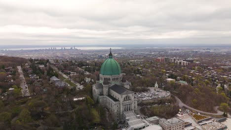 Aerial-view-of-Saint-Joseph's-Oratory-of-Mount-Royal,-Montreal-Quebec,-drone-reveal-scenic-cityscape-at-distance