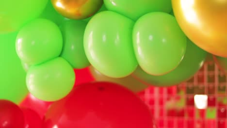 Camera-Tilt-Shot-Revealing-Colorful-Scene-of-Red,-Green,-and-Gold-Balloons-with-Cactus-wearing-mexican-Hat