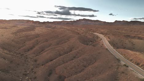 Hilly-Desert-Landscape-with-Winding-Road-Cutting-into-Mountains