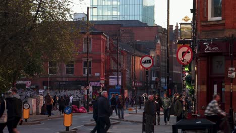 Busy-street-of-Northern-Quarter-of-Manchester-with-graffiti-on-walls-and-people-walking