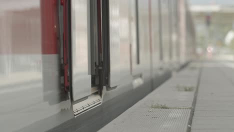 Close-up-of-a-person's-feet-stepping-off-a-train,-set-against-an-urban-backdrop