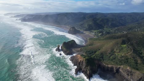 Lion-Rock-At-Piha-Black-Sand-Beach-On-Sunny-Morning-With-Mist-In-West-Auckland,-New-Zealand