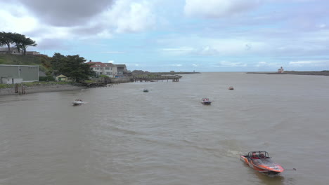 2024-UIM-World-Jet-Boat-River-Racing-Championship-in-Bandon-Oregon,-slow-drone-flight-over-boat-waiting-their-turn