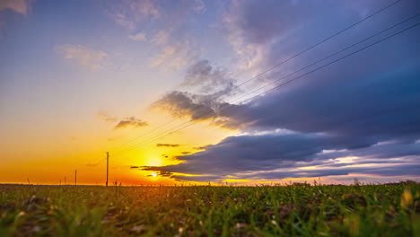 A-yellow-sunrise-in-a-blue-sky-over-a-green-field
