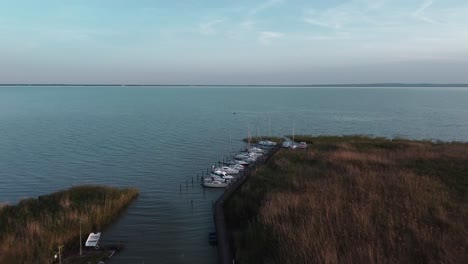 Drone-view:-Pier-on-Balaton-Lake,-sailboats-await-wind