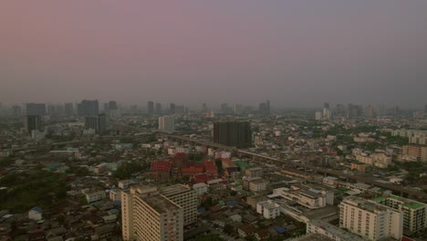 Vista-Aérea-De-La-Ciudad-De-Bangkok-Con-Niebla-Tóxica,-Edificios,-Drones-De-Marcha-Atrás