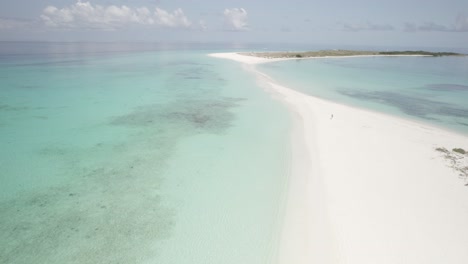 The-pristine-cayo-de-agua-with-turquoise-waters-in-los-roques,-venezuela,-sunlight-glinting-on-sand,-aerial-view