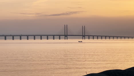 Una-Hermosa-Foto-Del-Puente-De-Oresund-Con-Un-Barco-Solo-En-El-Agua-En-La-Hora-Dorada---Malmo,-Suecia